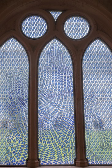 Colourful stained glass window with geometric patterns, the Pietà window by Thomas Bayrle, in the