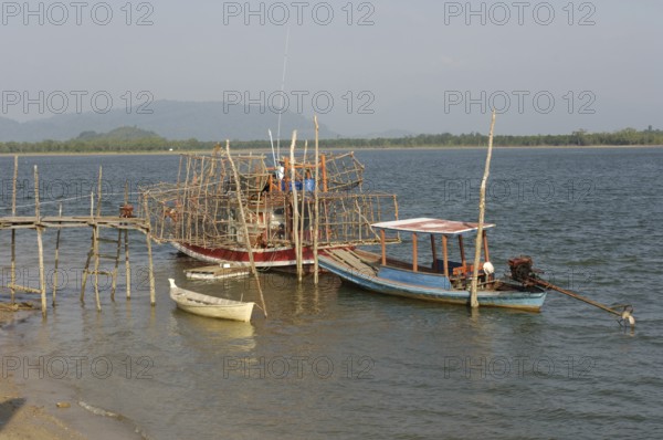 Small fishing boat on the right, boat on it lots of large bamboo traps, Phang Nga Phang-nga