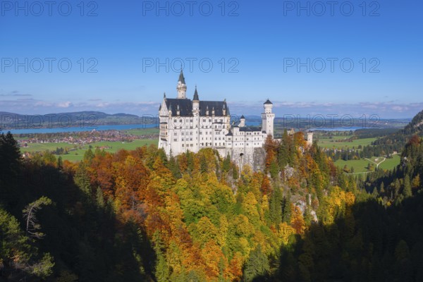 The fairytale Neuschwanstein Castle with autumn trees and views of the surrounding countryside,