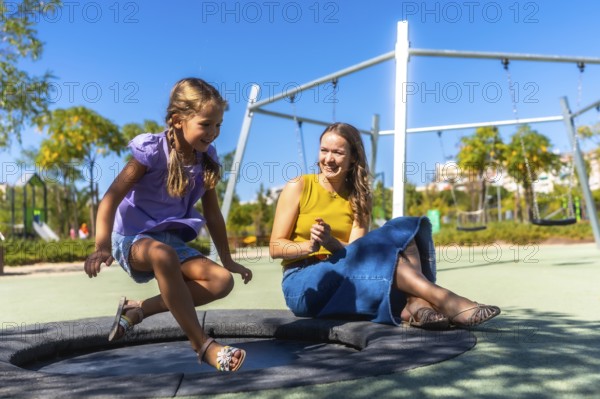 Mother and daughter enjoying time together, bonding and laughing while playing on an outdoor