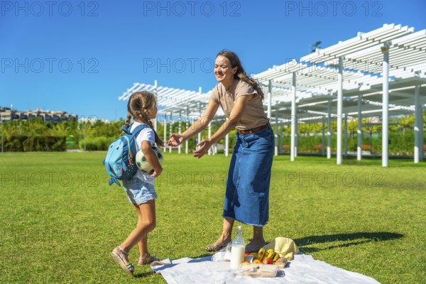 Mother and daughter enjoying a happy summer picnic in a park, parents spending quality time with