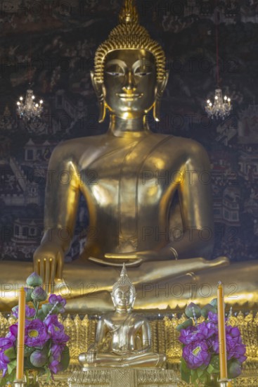 Golden Buddha statue, Phra Buddha Trilokachet surrounded by crystal chandeliers and exquisite wall