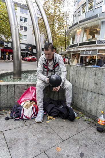 Man in public consumes laughing gas filled into a balloon with a gas cartridge, still legal