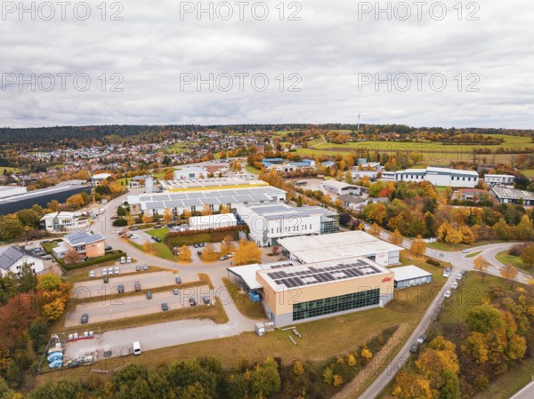 Industrial buildings and warehouses in a landscape with autumn trees and cloudy sky, Dornstetten,