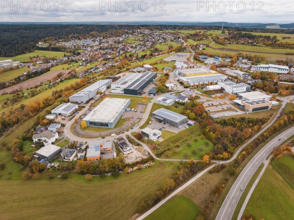 Extensive industrial area with autumn trees and buildings seen from an aerial perspective,