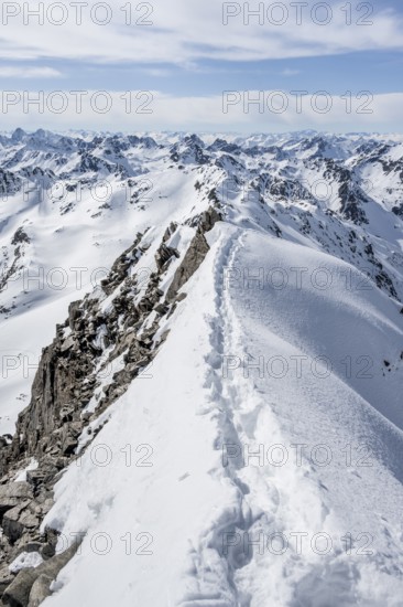 Narrow mountain ridge in winter, summit of Piz Grialetsch, view of mountain panorama with snow,