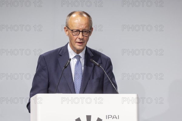 Federal Chancellor Friedrich Merz (CDU) . Portrait at the lectern with free text space.