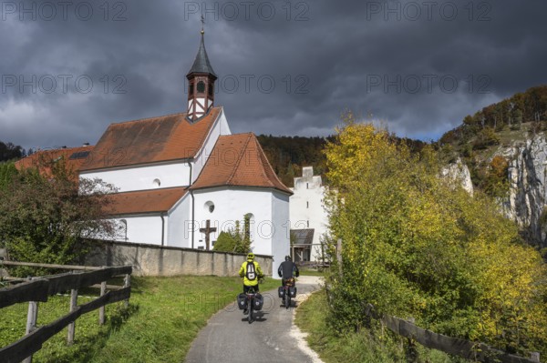 Cyclists on the Danube Valley Cycle Path in front of St. George's Basilica at Käppeler Manor near