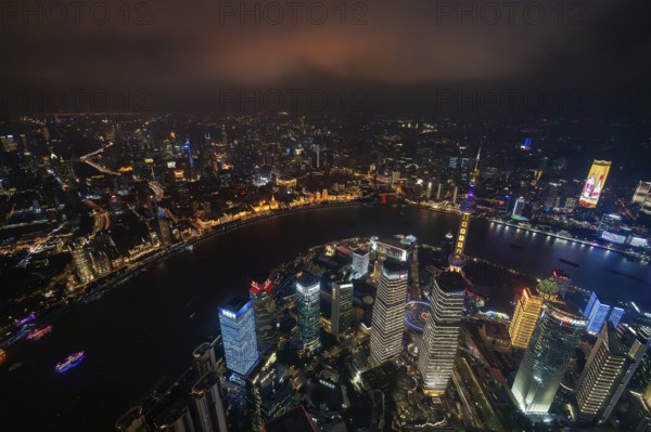 Aerial view over The Bund, Huangpu River and Lujiazui financial district with illuminated