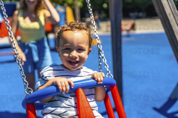 Happy toddler smiles while enjoying a swing ride at the playground, creating a joyful childhood
