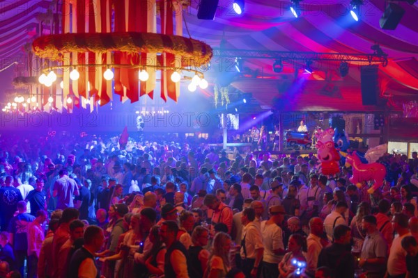 Cheerful celebration with light effects and live music, the crowd enjoys the festive atmosphere of