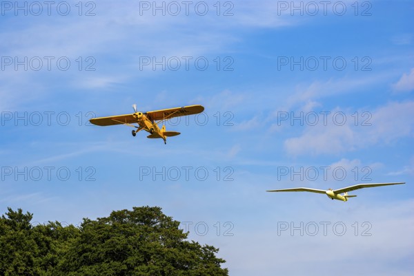 A Piper PA-18 Super Cub tows a glider during an air show at the Rossfeld in Metzingen-Glems,