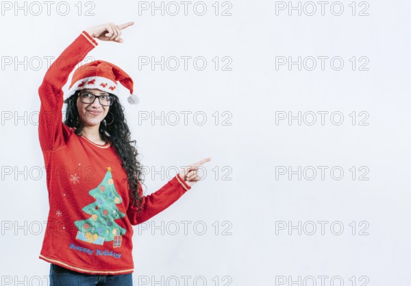 Happy young woman in Christmas sweater recommending and pointing aside. Smiling girl in Christmas