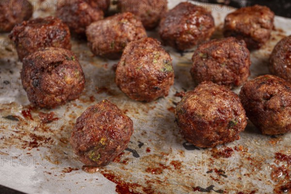 Homemade meatballs cooked to perfection on a baking tray with seasoning and herbs, Swedish