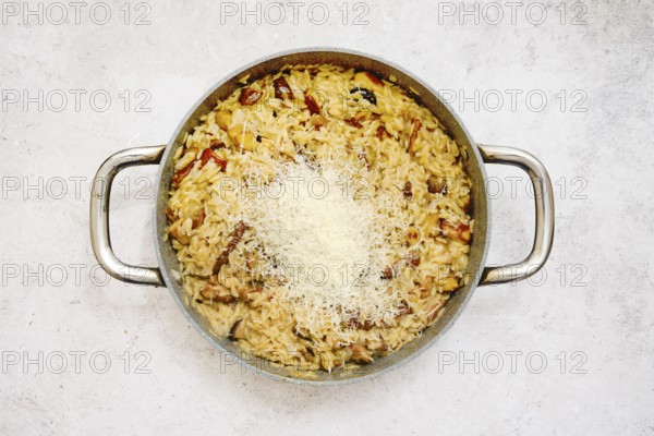 A delicious risoni dish with porcini mushrooms is presented in a pan. This comforting meal is