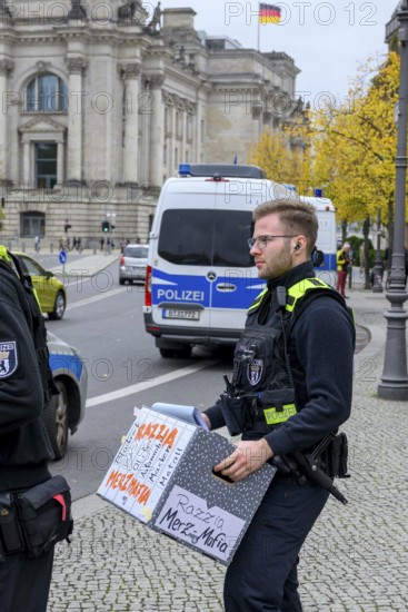 Police officers confiscate boxes from the symbolic house search of the New Generation under the