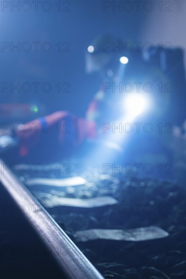 Blur of a person with a torch working on rails in the dark, fire drill in the new construction