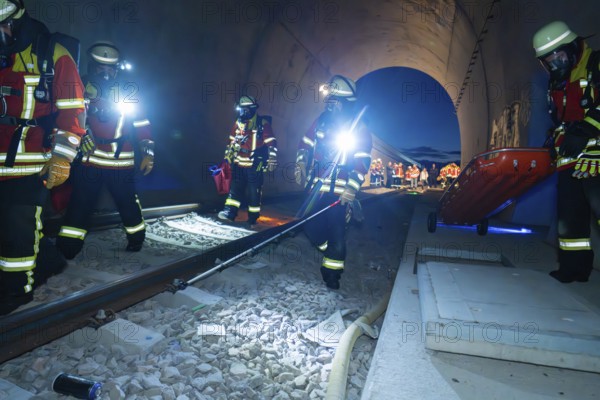 Firefighters in a tunnel at night, strong light illuminates the scene, firefighting exercise in the