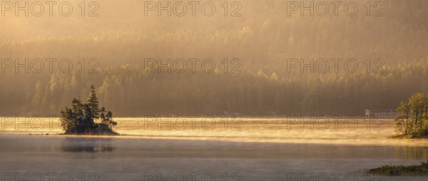 Morning atmosphere at the Eibsee lake, small island in the first light, Grainau near