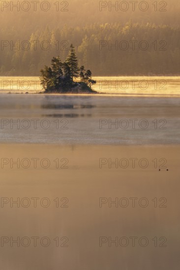 Morning atmosphere at the Eibsee lake, small island in the first light, Grainau near