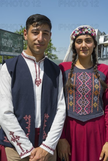 Close-up of a couple in traditional traditional costume in front of a sign, folklore, Tatev, Tatev,