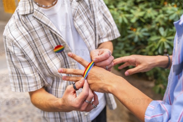 People are decorating their hands with rainbow colored adhesive tape, celebrating identity,
