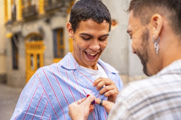 Gay man happily receiving a pride flag pin from his partner on a city street, joyful embrace and
