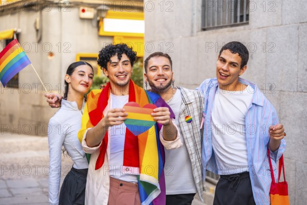Diverse group of young adults smiling and celebrating pride in the city, holding a rainbow heart