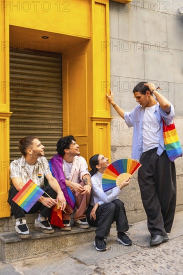Group of four diverse friends celebrating lgbtq plus pride in the city, waving rainbow flags and a