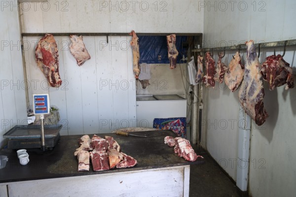 A butcher's room with pieces of meat on hooks and a table with scales, Martuni, Gegharkunik
