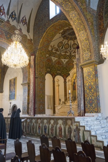 Monks pray in the magnificently decorated church with altar and chandelier, Inside the historic,