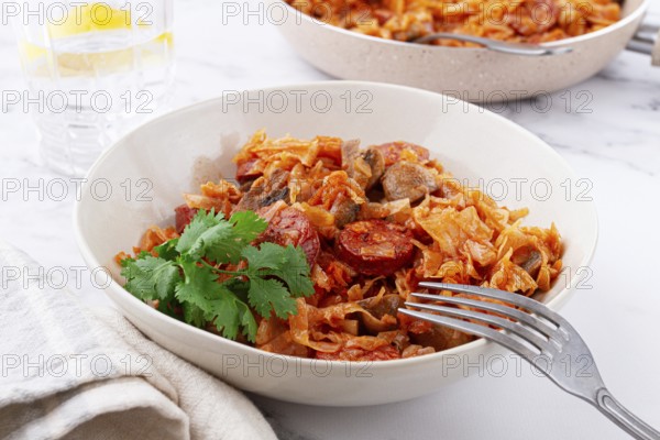 Bigos, Polish dish bigos, on the table, pan with stewed meat, with cabbage, chorizo sausages,