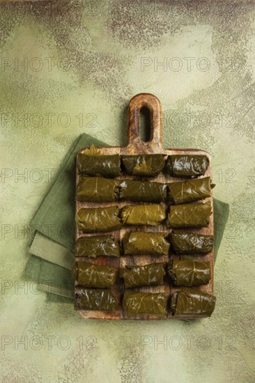 Dolma, minced meat with rice, in grape leaves, minced meat rolls, on a chopping board, top view, no