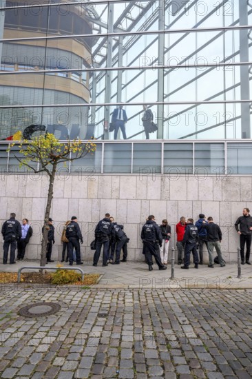 Men look out of the Konrad Adenauer House. Below, police detain activists of the New Generation.