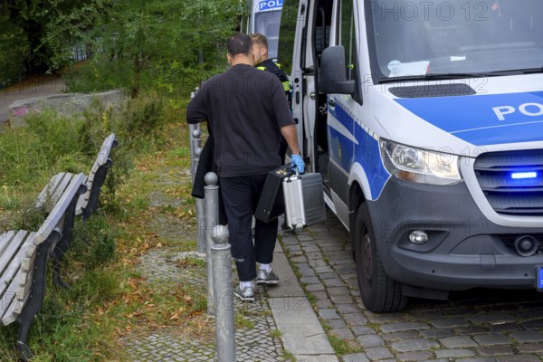 Police officers confiscate what looks like a suitcase after a search of the CDU federal office by