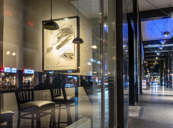 Urban scene in the evening with reflections of Friedrichstraße in the window pane of a bistro,