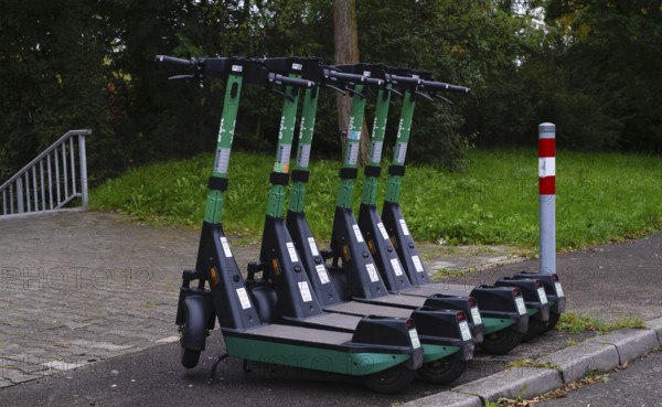 Several e-scooters, electric scooters, scooters parked on the pavement, pavement, in the Bolt bike