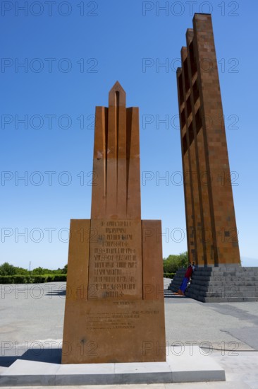 A tall red stone monument against a clear blue sky, Sardarapat Monument, Araks village, Armavir
