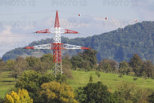 High-voltage pylon with signalling paint in front of the landscape of the Swabian Alb. Kirchheim
