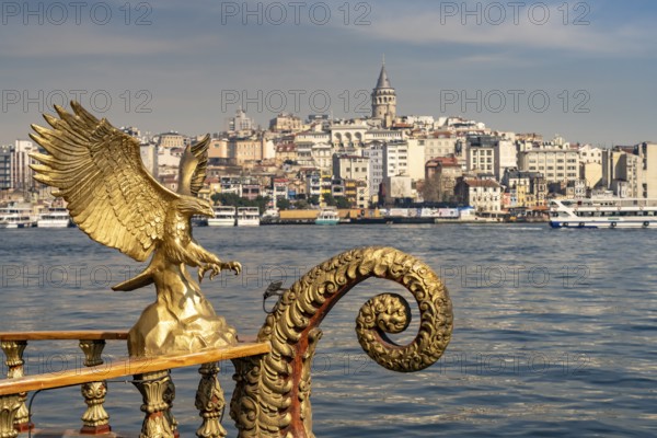 Golden oriental restaurant ship on the banks of Eminönü, Beyoglu and the Galata Tower, Istanbul,