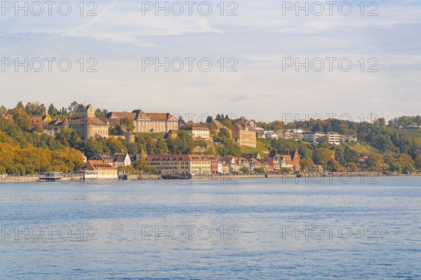 Town view on the lakeshore with historic buildings and autumnal trees under a blue sky, Meersburg,