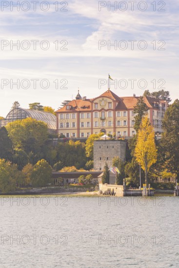 Historic castle on the lake with autumn trees and cloudy sky, Mainau Island, Lake Constance,