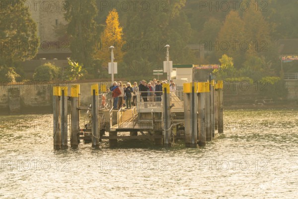 Group of people gathering on a jetty in sunny autumn weather, Mainau Island, Lake Constance,