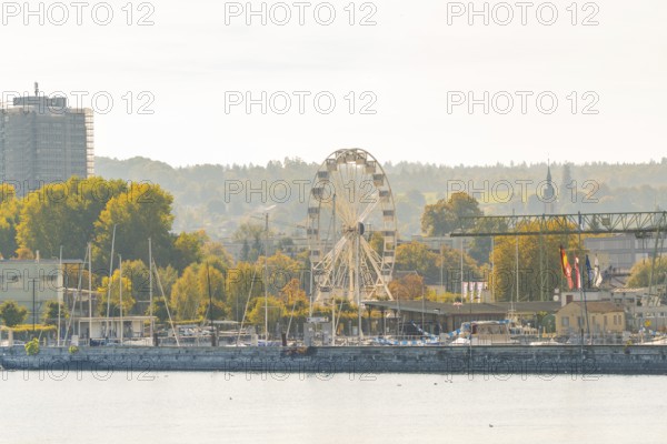 Harbour panorama with Ferris wheel and autumnal trees under a clear sky, Constance, Lake Constance,