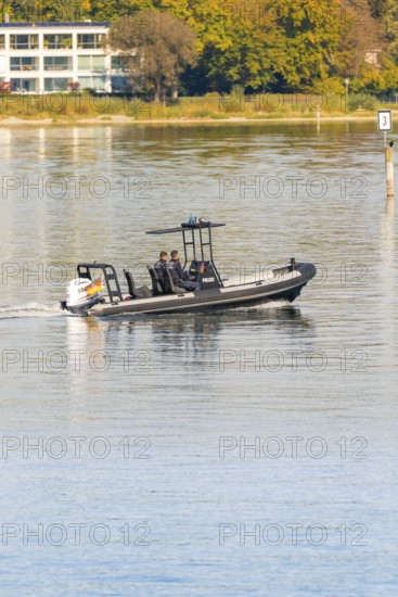 People in a police motorboat gliding across the calm lake on a sunny day, Constance, Lake
