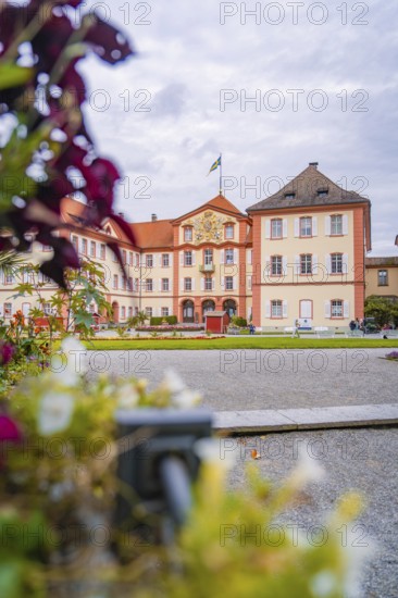 Historic castle building with manicured garden and blooming flowers in the foreground, Mainau