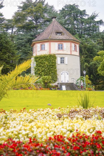 Round tower in the garden, surrounded by blooming flowers, Mainau flower island, Lake Constance,