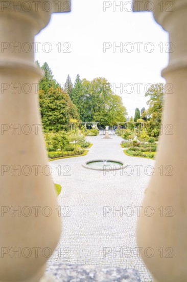 View of manicured path with fountain through decorative columns, Mainau flower island, Lake