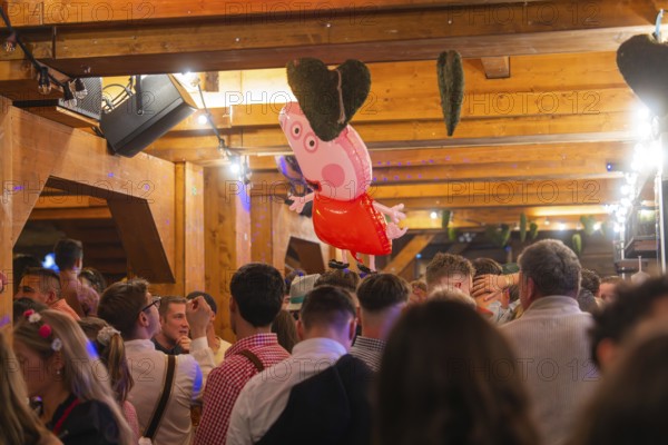 Crowd in a venue with wooden elements and decorations, Cannstatter Wasen folk festival, Stuttgart,