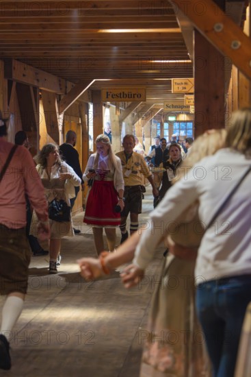 Interior shot of a marquee area with people in traditional Bavarian traditional costume, cheerful